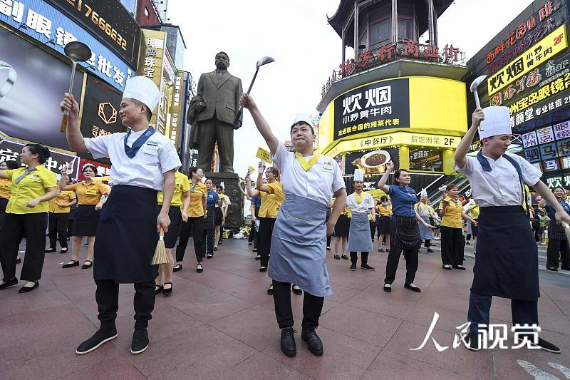 2020年8月5日，当日，湖南长沙黄兴路步行街的百余位厨师、服务员等餐饮从业者，手举锅铲、勺子、菜单等道具跳起《无价之姐》的舞蹈，用快闪方式庆祝长沙餐饮业复工。 杨华峰(湖南分社)/中新社