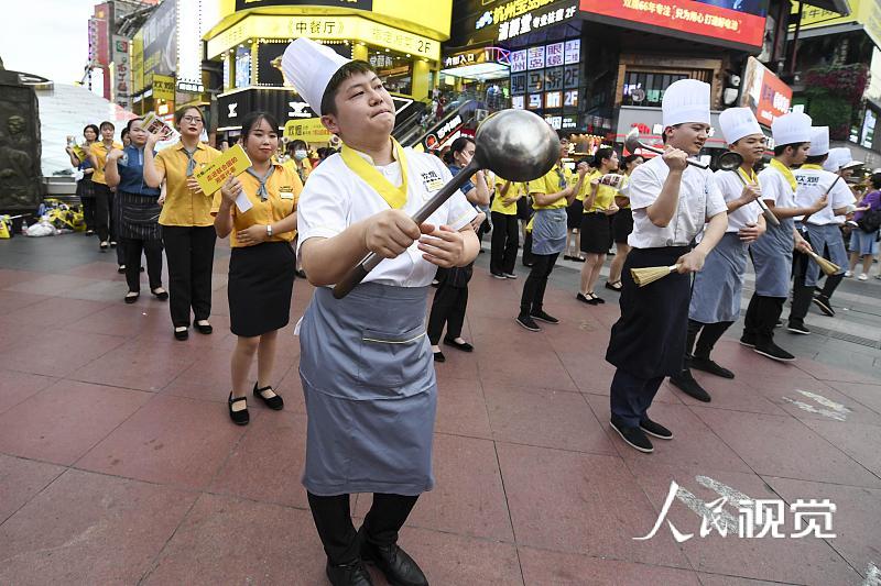 2020年8月5日，当日，湖南长沙黄兴路步行街的百余位厨师、服务员等餐饮从业者，手举锅铲、勺子、菜单等道具跳起《无价之姐》的舞蹈，用快闪方式庆祝长沙餐饮业复工。 杨华峰(湖南分社)/中新社