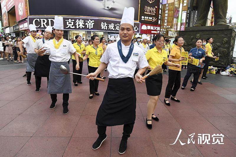 2020年8月5日，当日，湖南长沙黄兴路步行街的百余位厨师、服务员等餐饮从业者，手举锅铲、勺子、菜单等道具跳起《无价之姐》的舞蹈，用快闪方式庆祝长沙餐饮业复工。 杨华峰(湖南分社)/中新社