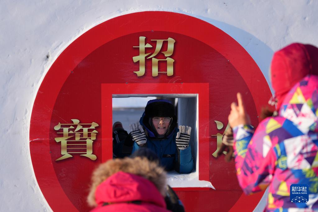 12月24日，在太阳岛雪博会园区，游客在一处体验式雪景中游玩拍照。新华社记者 王建威 摄