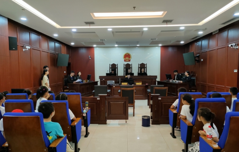 长沙县大学生普法志愿者通过模拟法庭普法。