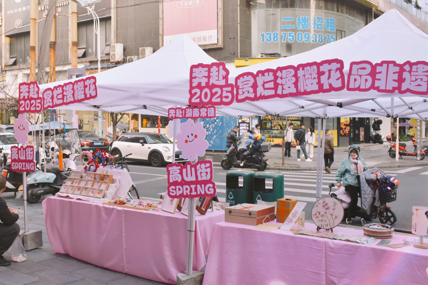 3月7日，2025年常德武陵高山街赏春消费季活动来袭。高山街人来人往，街边樱花悄然盛开，商铺热闹非凡。高山街盘活“赏花经济”“打卡经济”，装扮浪漫唯美城市风景，营造美好生活消费场景。老街区人气渐渐旺了起来，市场活力不断激发。