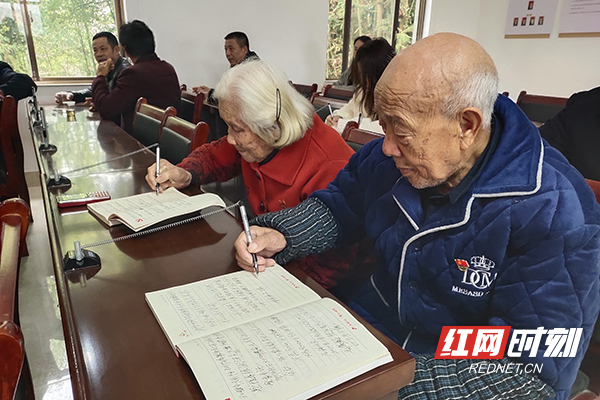 群丰镇新塘社区党龄70年的周霞生和党龄50年的王秀英两夫妇边看视频边认真作笔记.jpg