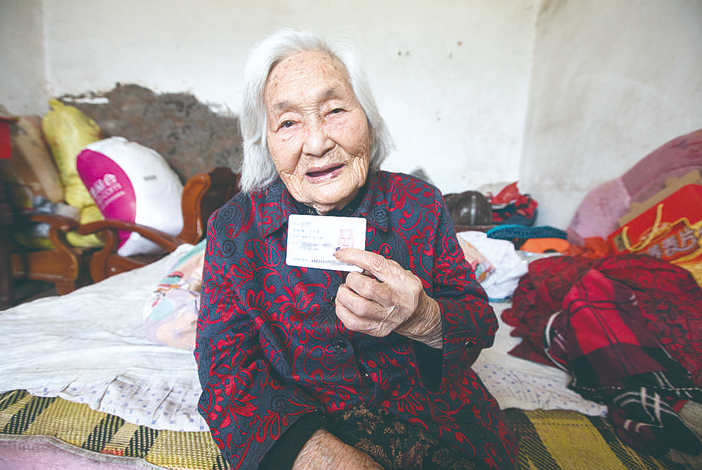 生于上个世纪初的文奶奶展示身份证。 记者 张媛 摄.png