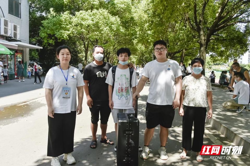 迎新志愿者们热情地为新生一边提行李，一边介绍学校情况，引领新生向宿舍走去。