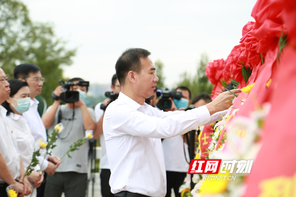 市委书记朱洪武仔细整理花篮上的红色缎带。