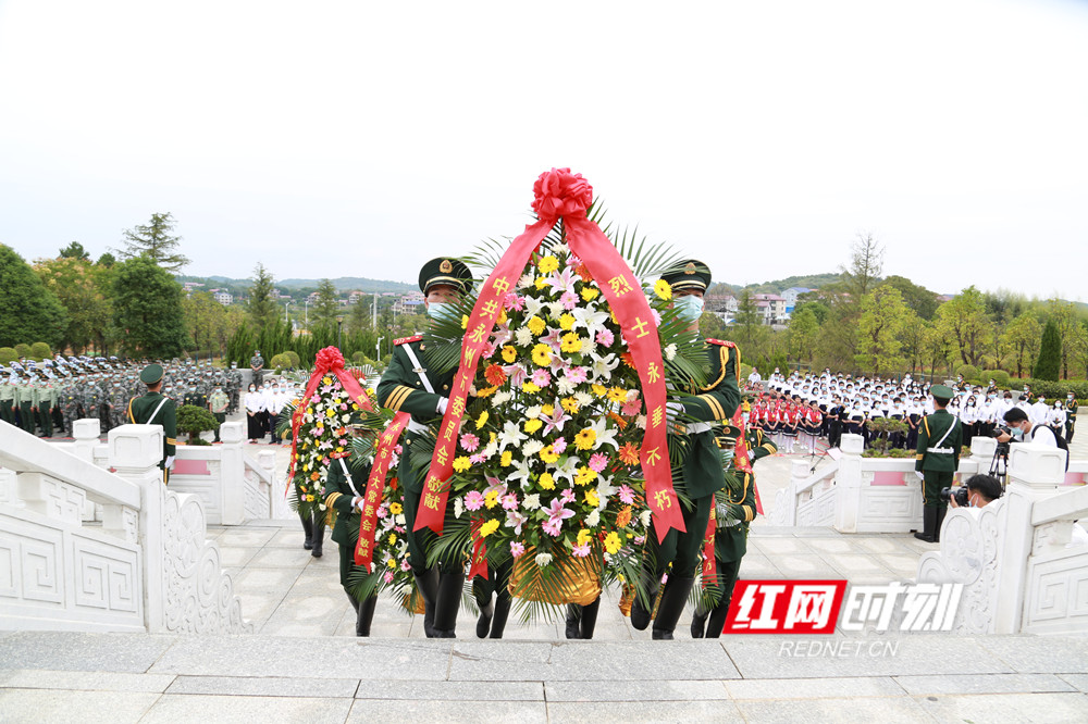 礼兵缓缓正步拾级而上，将花篮敬放在烈士纪念碑基座前。