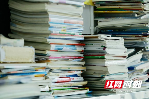 课桌上堆积的书本，是高考备考路上努力的见证。.marked.jpg