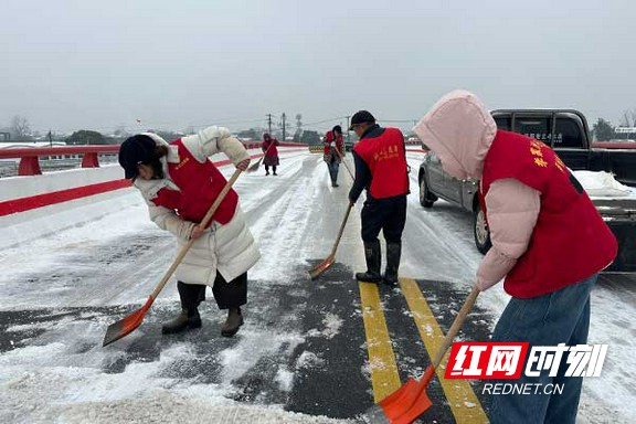 会龙山街道李家洲社区党员志愿者对结冰桥梁路段采取撒盐应急措施。.marked.jpg