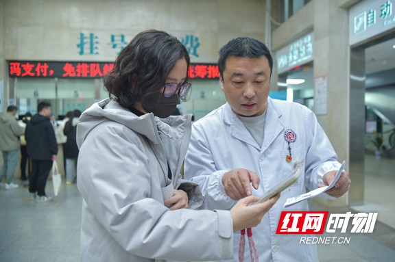 医院工作人员向患者介绍门诊共济线上报销流程1.wm.jpg