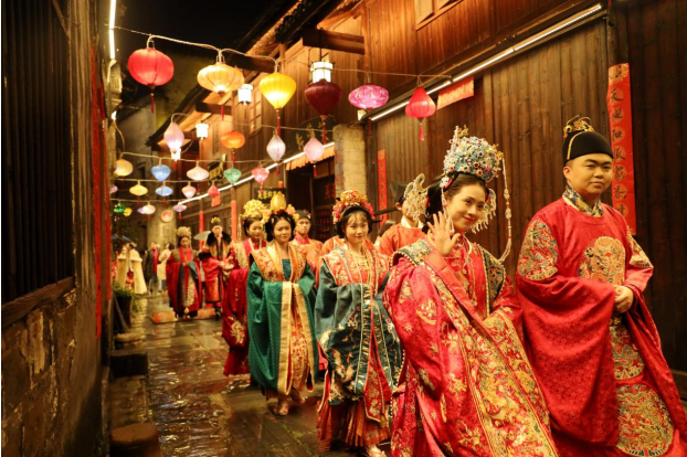 1月19日晚，身着汉式婚礼服的一对对“新人”在洪江市黔阳古城夜游。当晚，黔阳古城举行“汉婚大典”，吸引了众多游客参与体验“穿越之旅”。 （李 粉）