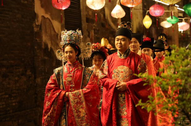 1月19日晚，身着汉式婚礼服的一对对“新人”在洪江市黔阳古城夜游。当晚，黔阳古城举行“汉婚大典”，吸引了众多游客参与体验“穿越之旅”。 （李粉）
