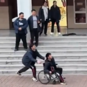 男生腿受伤坐轮椅 课间好友推着他打羽毛球