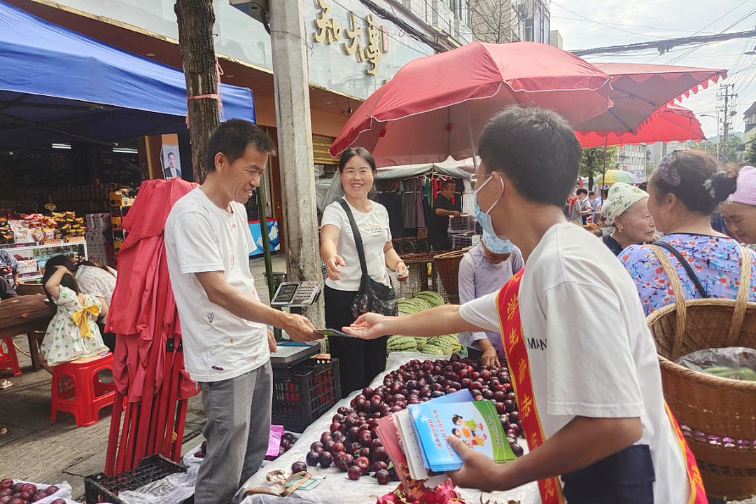 7月20日，正是湘西凤凰县阿拉圩场日，凤凰县司法局组织大学生普法宣传小分队来到集市中心，向前来咨询的各族群众解答法律知识，将法律手册一一发放到店铺和商贩手中。