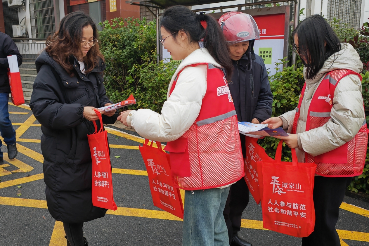 湘潭县白石镇农贸市场周边，20余名刚放寒假的大学生忙碌穿梭，用通俗易懂的语言和方式向群众普及法律知识。