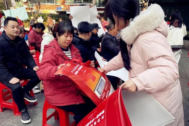 衡阳市珠晖区司法局组织返乡大学生向群众赠送手提袋和年历大礼包。