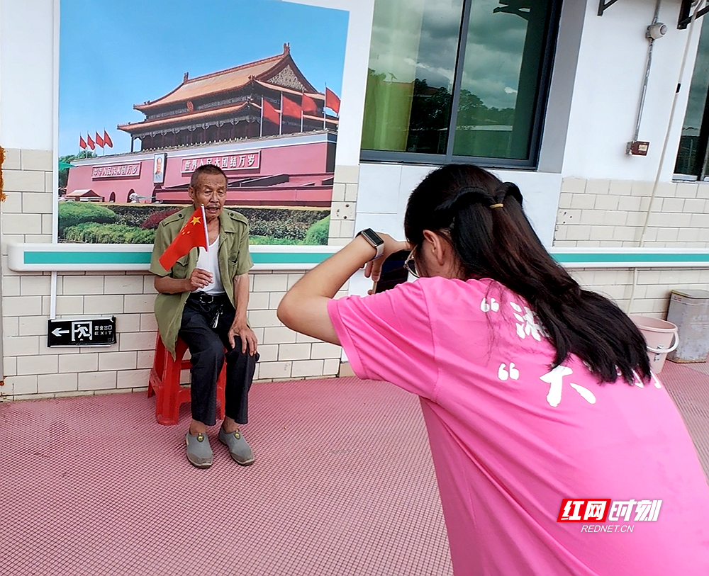 团队成员为老人拍摄照片.png