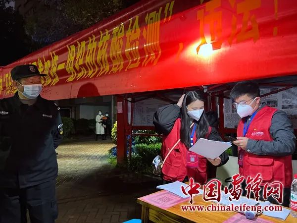 夜幕降临，志愿者刘晓云与石泽新核对信息。图片来源：湖南雷锋纪念馆.jpg