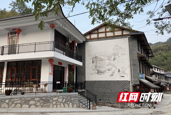 白墙灰瓦的具有土家族特色的民居在道路两旁次第排开.jpg