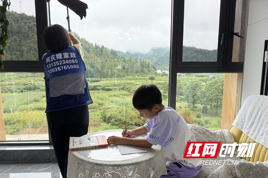 周绪萍在客户家打扫，儿子在一旁安静写作业。 (2).jpg