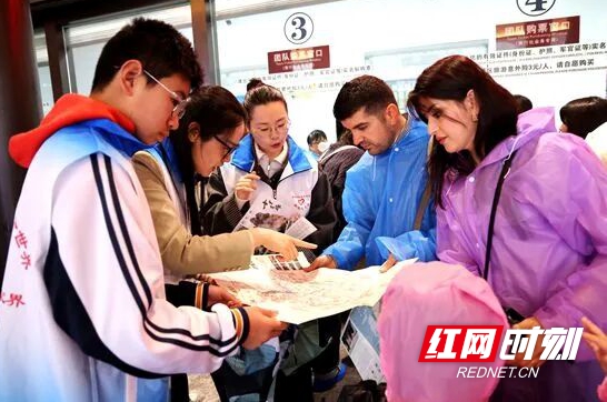 青年志愿者为入境游客讲解游览线路。.jpg