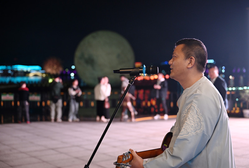 5月3日晚，资兴市东江花月夜雅阁码头，演员在表演弹唱节目，吸引了不少游客及市民驻足观看。_副本.jpg