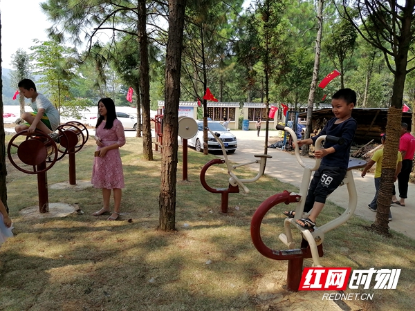 村容村貌大变样，小孩在体育器材上悠闲的锻炼身体。.jpg