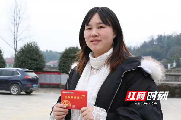 桃江县武潭镇罗家坪村村民薛丽在办理完贷款授信手续后，手拿贷款授信卡，难掩心中喜悦。1.jpg