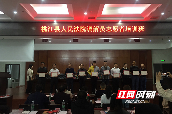 桃江县人民法院正在为调解员志愿者颁发聘书。1.jpg