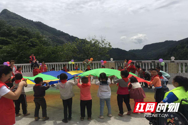 孩子们正在玩“彩虹伞”游戏。.png