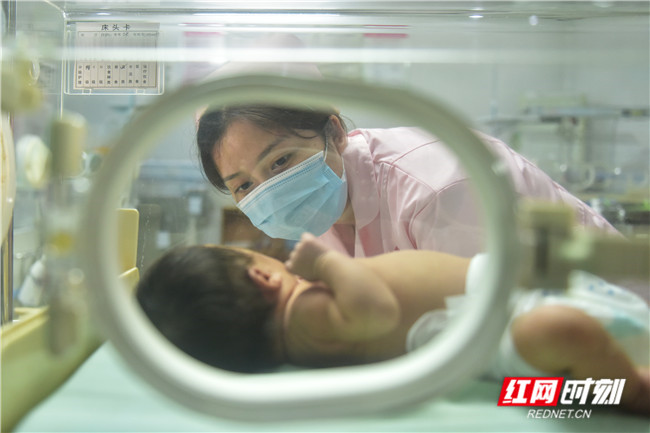 医护人员正在新生儿科查看新生儿健康状况。