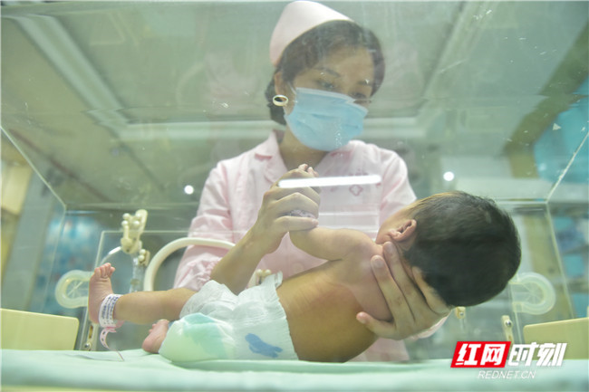医护人员正在新生儿科查看新生儿健康状况。