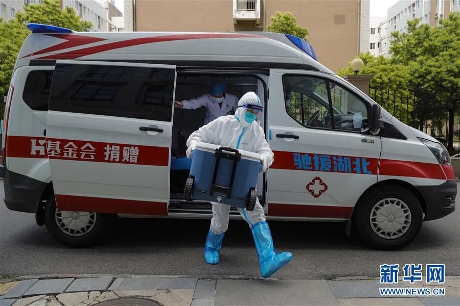 4月24日，武汉协和医院心外科医生卢雄豪（右）在运送供肺前往武汉协和医院西院区的路上更换防护服。