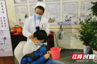 怀化市中医医院展位里，不少市民排队体验艾灸和刮痧。