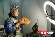 记者看到，许多展区都设有直播间，为网友们介绍参展的商品。图为一位会同的主播向网友们展示家乡的桔子。