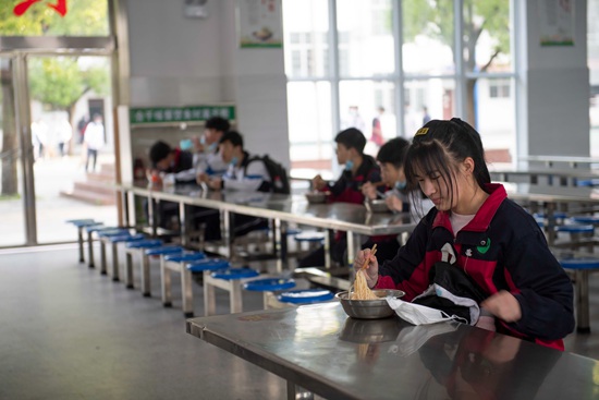 打好餐后，同学们有序就坐，安静用餐。（陈湘清 摄）