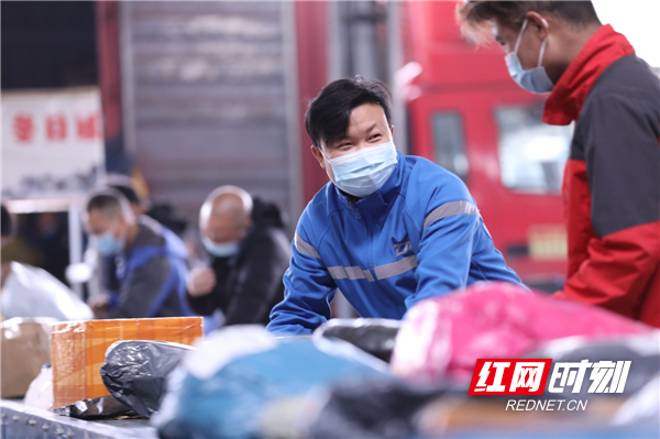 11月12日，在中通快递道县分拣中心，工作人员在流水线上分拣快递包裹。