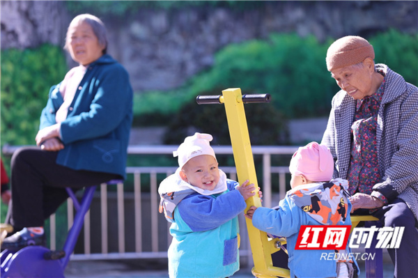 红网时刻12月2日讯（通讯员 何真启 何红福）12月1日，改造过后的道县财政联合小区，老人带着小孩在健身器材上玩。