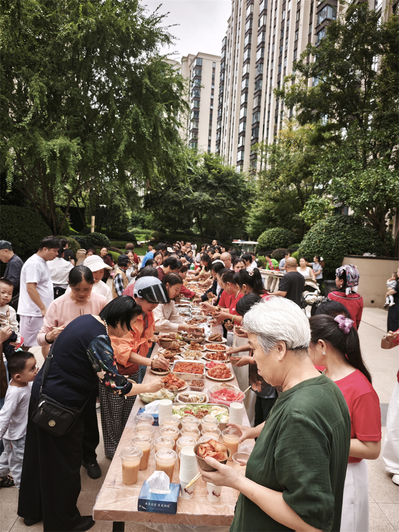 各族居民围坐共享特色美食,闲话家常,在欢声笑语中拉近邻里距离,厚植民族团结根基。.jpg