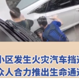 小区发生火灾汽车挡道  众人合力推出生命通道