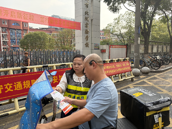 图三朝阳社区文明交通劝导员到辖区校园周边开展交通劝导工作。（黄海萍 摄）_副本.png