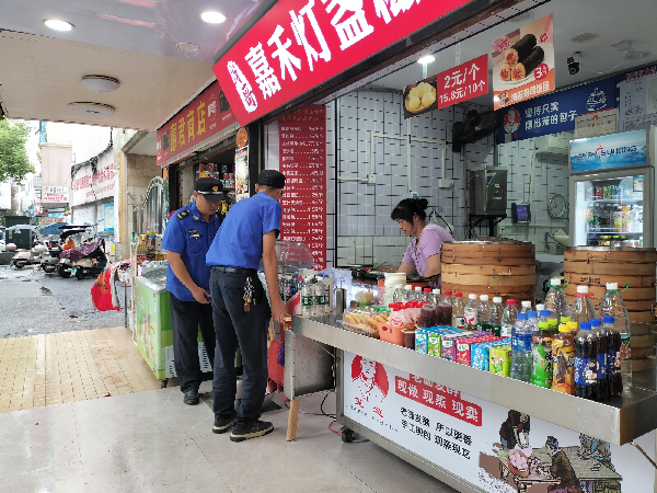 图五燕泉城管执法人员对辖区内校园周边商户占道经营现象进行劝导。（姚润霞 摄）_副本.png