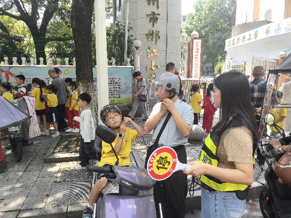 图二燕北社区文明交通劝导员到辖区校园周边开展交通劝导工作。（李洋 摄）_副本.png