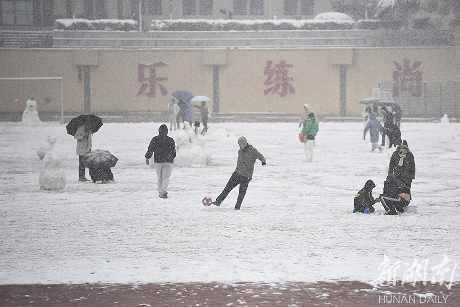 The photo, taken on December 26, shows residents playing football and making snowmen at Hunan University. Influenced by strong cold air, Changsha city proper greeted its first snowfall this winter that day.(Photo/Gu Pengbo, Hunan Daily)