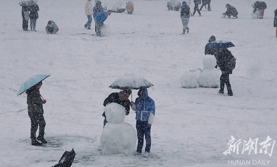 The photo, taken on December 26, shows residents making snowmen at Changsha University of Science and Technology. Influenced by strong cold air, Changsha city proper greeted its first snowfall this winter that day. (Photo/Xu Xing, Hunan Daily)