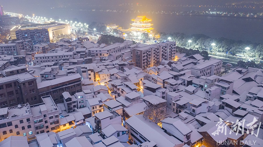 The photo, taken on December 26 evening, shows the snow-covered buildings near Douchiyuan Lane, Tianxin District, Changsha. Influenced by strong cold air, Changsha city proper greeted its first snowfall this winter that day. (Photo/Gu Pengbo, Hunan Daily)