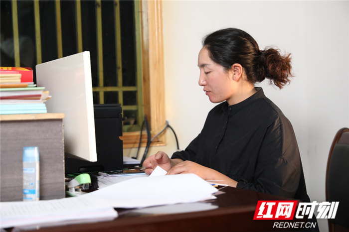 郑小红在办公室整理资料（摄影：陈红旭）.png