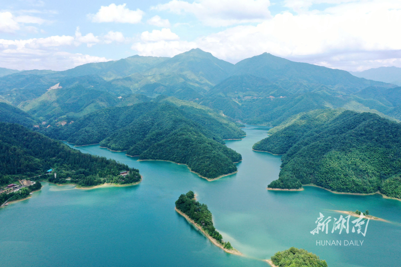 6月25日，蓝天白云下的城步苗族自治县白云湖国家湿地公园核心区域，群山叠翠，湖水碧澈，岸边人烟稀少，呈现一派人与自然和谐相生的美丽画卷。近年，城步苗族自治县白云湖国家湿地公园深入贯彻绿色发展、生态优先理念，通过拆除网箱养鱼、餐饮游乐船，以及实施严格的封禁、修复、执法等措施，域内生态环境得到了显著改善。严钦龙 摄