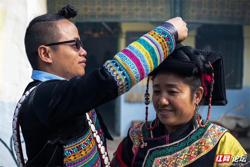 11月20日是当地彝族同胞过大年的日子,普昌镇哈木足村村民李浩磊帮助妈妈穿戴节日服饰。.jpg