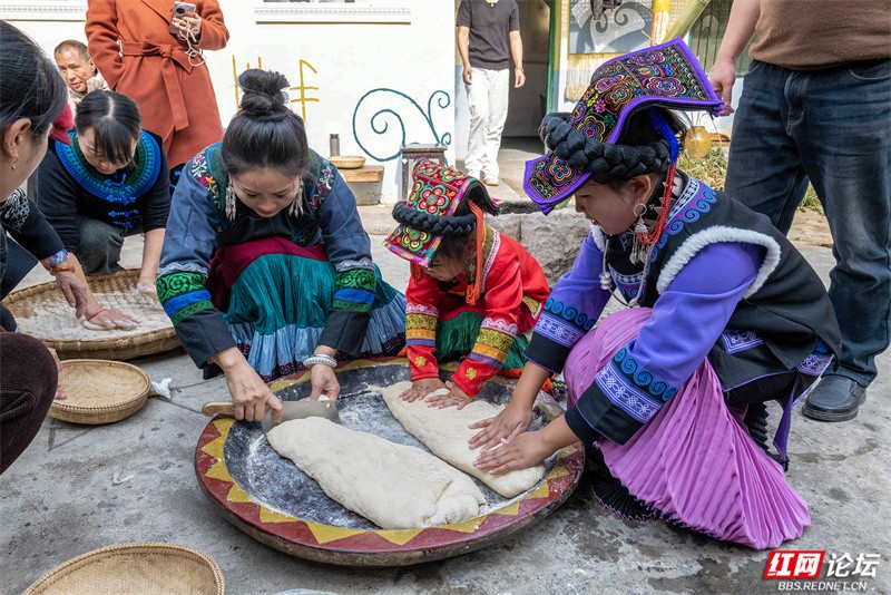 打糍粑在彝年活动中不可或缺。这位母亲带着孩子将刚刚打好的热糍粑分给大家享用。.jpg